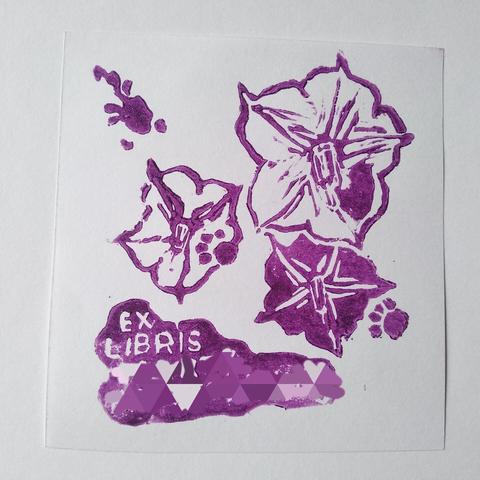 Linocut print, violet on white three potato flowers, 2 white and 1 violet, letters "ex libris" and cats paws "walking" diagonally thru print, third as a inkspot only