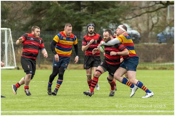 A high tackle on the home rugby player by an opponent.