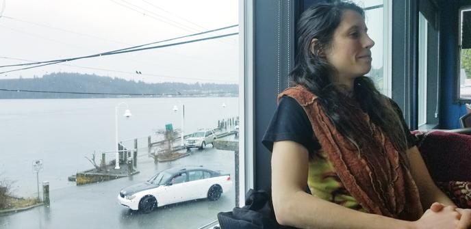 GuidingStar sitting at restaurant with ocean view in background.