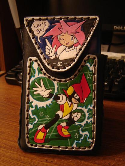 A handmade leather case for a Nintendo DSiXL console, with tooled and painted rawhide leather panels showing Pulseman and Beatrice from the Mega Drive game Pulseman (1994).
