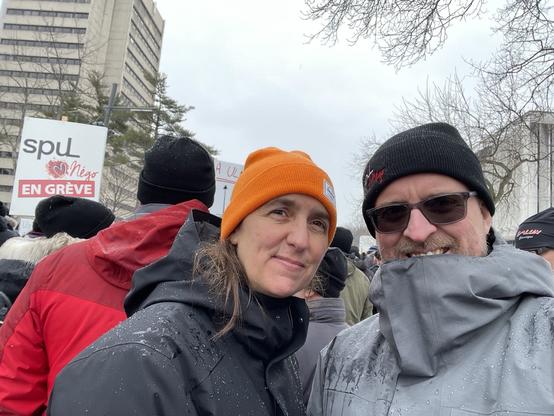 Une femme et un homme posent pour la caméra durant une manifestation