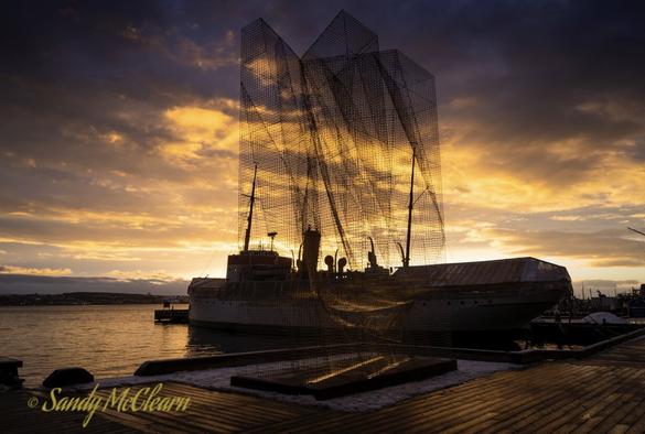 Ship and wire sculpture silhouetted again the early morning sky.