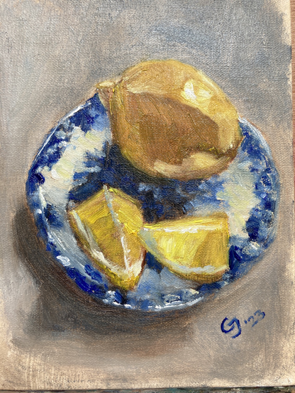 Oil painting of lemon slices and a lemon on a blue and white transferware plate