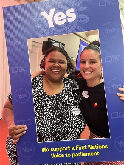 Our First Peoples Advisor Sam Gledhill and Uniting NSW.ACT's Holly Thorburn hold up a large instagram cardboard frame that says 'Yes, We support a First Peoples Voice to Parliament'.