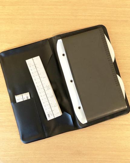 The wallet open to reveal a stack of vertical paper "index cards" and, on the opposite side of the wallet, large magnetic tape belts - the 'dictabelts' the IBM 224 records onto.