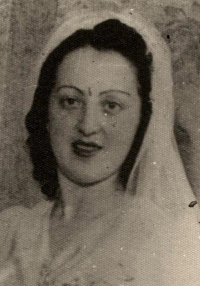 A photo of a dark-haired woman in her white wedding dress.