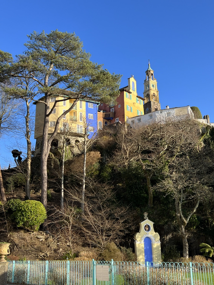 Postmodern Italianate architecture  in a rocky landscape with tall trees and blue skies