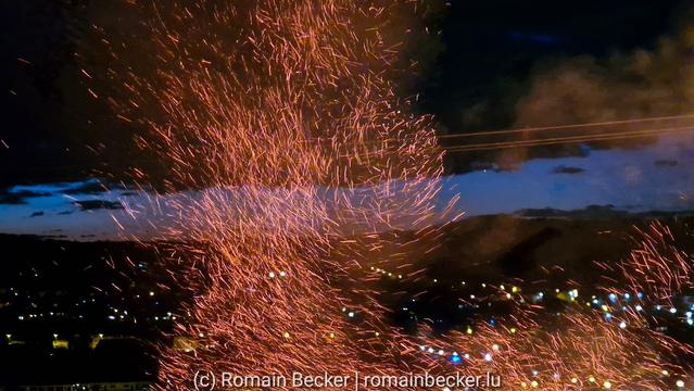 A bonfire burns and ashes are flying like a whirlwind in the air.