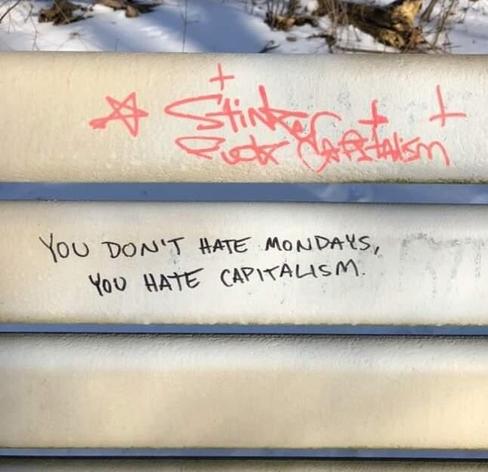 "You don't hate Mondays, you hate capitalism" written on a crossbeam fence with black marker