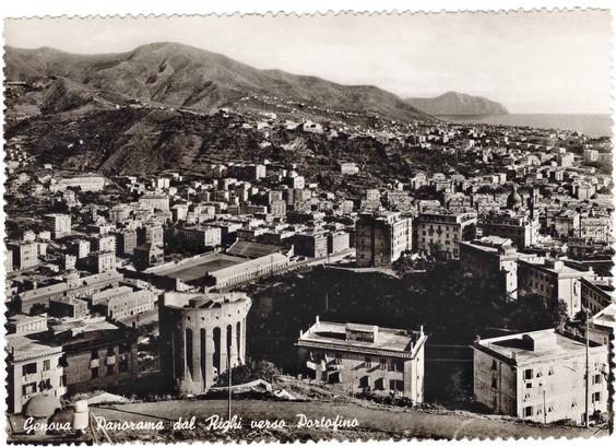 Foto in bianco e nero con vista dalle alture del Righi. In primo piano, una torre da fortificazione. Al centro lo stadio e sullo sfondo mare e monti.