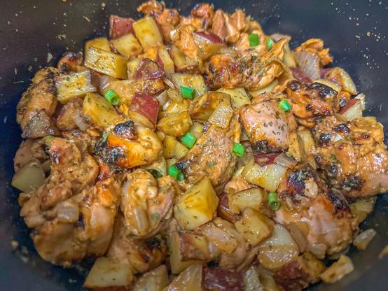 Roasted chicken and potatoes garnished with scallion