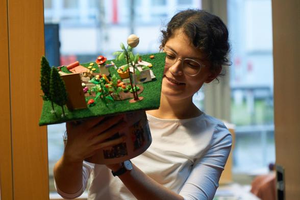 Photo of Theresa Lang holding her PhD hat after her defense.