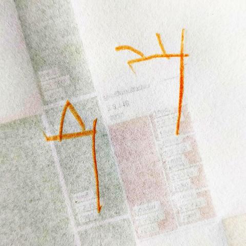 Two attempts at writing the digit 4 in orange crayon on the back of a technical schematic of a building. One of the 4s has three upward prongs, the other is a triangle with a dislocated, long right leg.