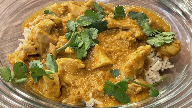 Turmeric colored Hyderabadi chicken curry on brown basamaiti rice
