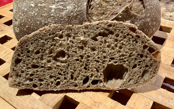 A slice of bread is shown with a complex crumb with many holes.
