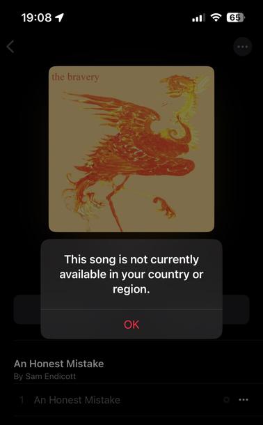 Screenshot showing error message “This song is not currently available in your country or region.” when trying to play the song “An Honest Mistake” by The Bravery via Apple Music on an iPhone.