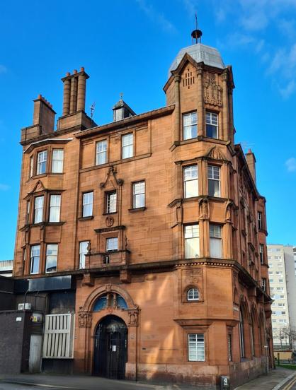 A red sandstone building in the Art Nouveau style against a blue sky.