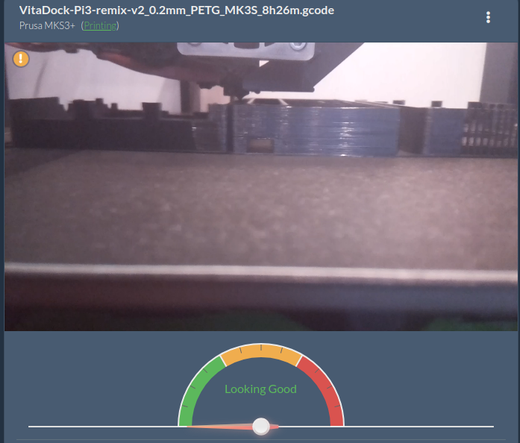 A 3d printer y-axis camera showing a black object being printed. The object is titled "VitaDock-Pi3-remix-v2"
