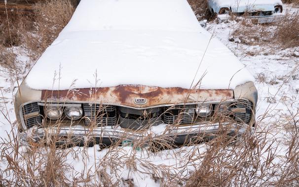 Front view of a very rusty Chevy. XL badge on the radiator. Stands in deep snow