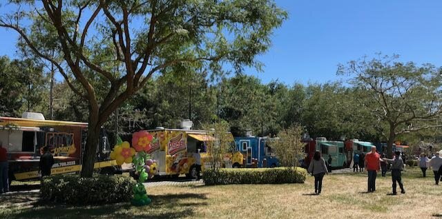 People ordering from a line of food trucks