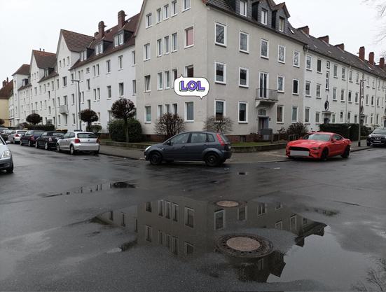Blick auf eine Straßenkreuzung. Ein Auto wurde an der Ecke abgestellt