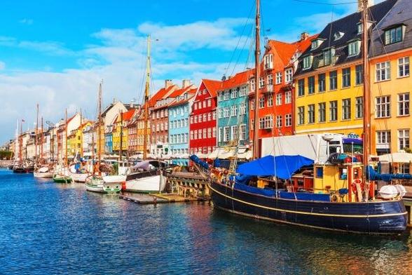 Photo of Copenhagen's Nyhavn harbor with colorful houses and boats.