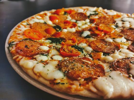 Pizza on a black reflective table.