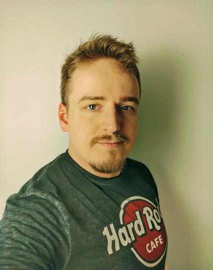 A man with a green shadow against a white wall.