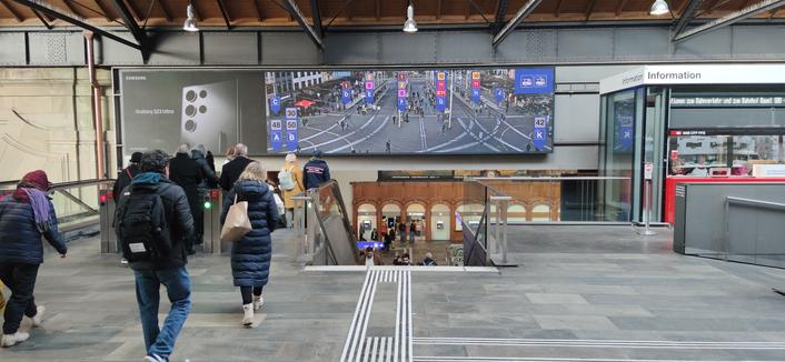 Hall of Basel train station has a live camera showing the tram and bus platforms outside with names and numbers overimposed.