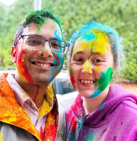 A couple covered in holi colors taking a selfie
