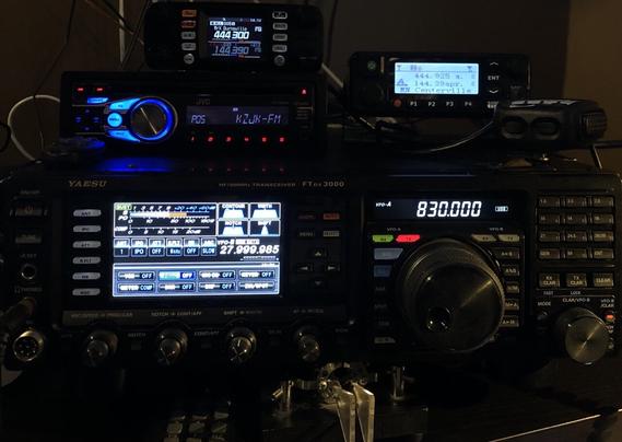 Radios stacked.
Top row left, Yaesu FTM-300D.
Top right, MD-9600 (connected to pi thru RigBlaster to run APRS iGate).
Below FTM-300 is a JVC KD-HDR44 car stereo tuned to KZJK-FM HD.
Beneath all those: FTdx3000.