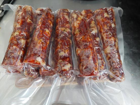 Several pieces of homemade pepperoni vacuum sealed in a plastic bag.