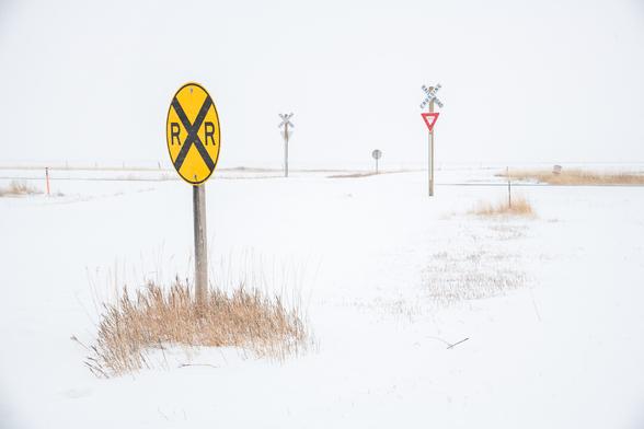 Very minimal shot - snowscape with 4 railway road crossing signs standing in the snow