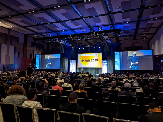 A SXSW stage and speaker, with hundreds of people sitting and watching.
