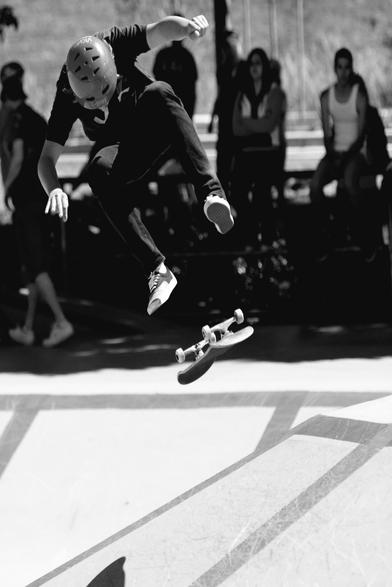Skateboarder & board in middair - board is upside down.  Monochrome.