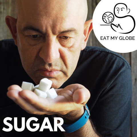 Simon Majumdar holding a sugar cubes. Includes the text, “Sugar.” Also includes the Eat My Globe logo of Simon Majumdar's likeness using the initials "S" and "M" holding a globe on a platter with the words, "Eat My Globe," underneath.