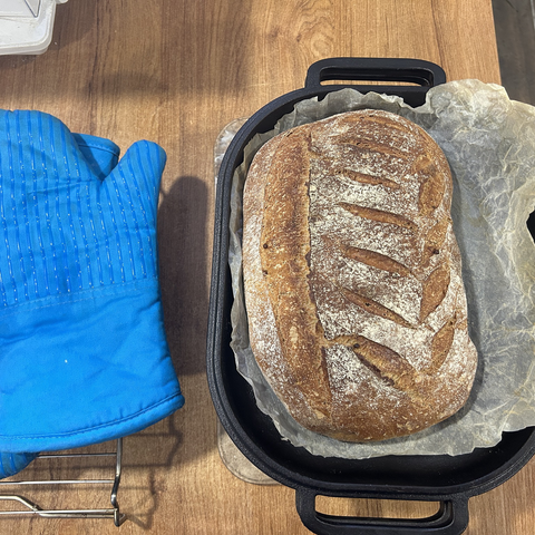 Same camera position: this is after 20 more minutes of baking with the lid off. The bread is now a dark brown (with white patches where the flour clung to it.)