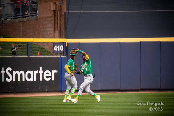 Oakland A’s outfielder Esteury Ruiz catches a fly ball hit to center field as teammate Denzel Clarke backs up the play.