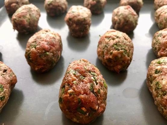 Moroccan Kefte, shaped and ready to go in to the oven. the ground lamb lozenges are flecked with herbs.