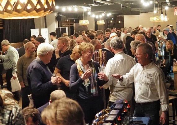 Foto van de zaal in het Heracles-stadion met vele bezoekers genietend van hun whisky.