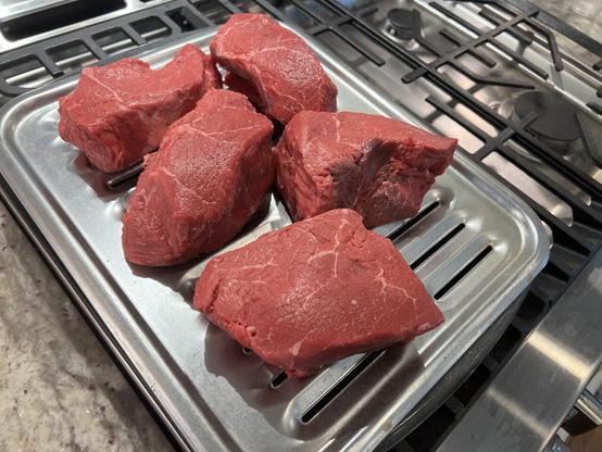 Raw steak on a broiler pan