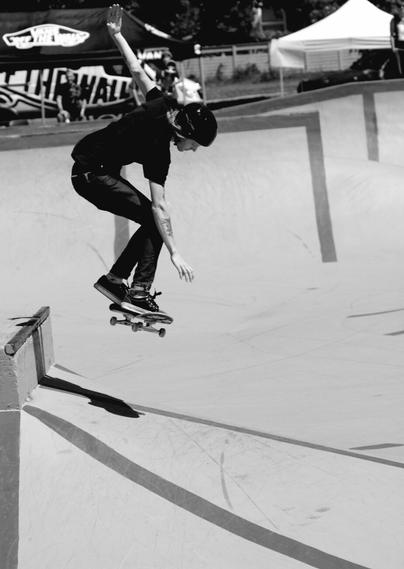 Skateboarder coming off a jump.  At skate park. Black and white photo.