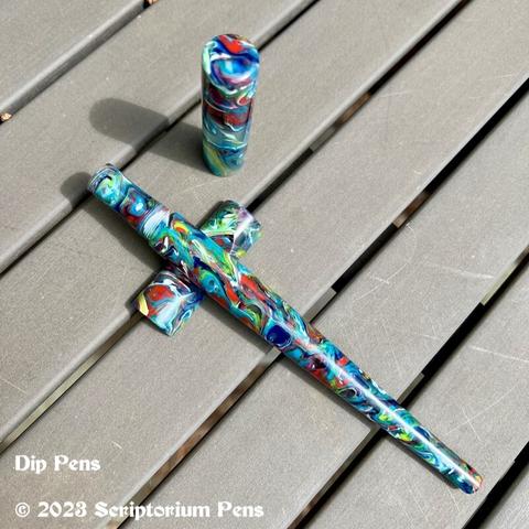 Long custom dip pen with cap, on handmade pen rest on table.