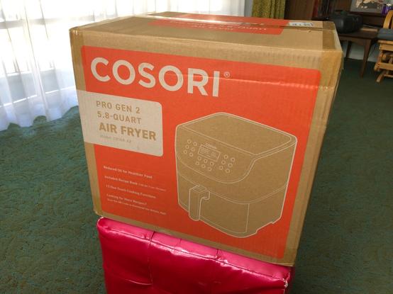 Cardboard shipping box containing a replacement Cosori air fryer.