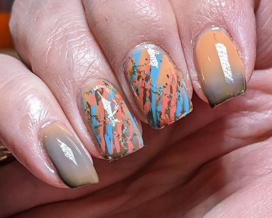 Four fingers with the little and index fingers showing the warm colour of blue fading into brown at the nail tips
