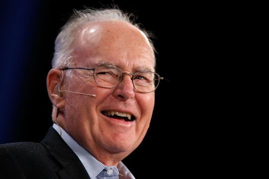 Gordon Moore with glasses, laughing. A long slender microphone is attached behind his right ear