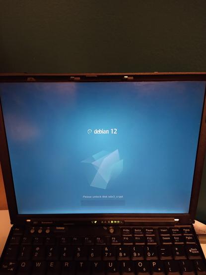 Small 4:3 screen showing debian 12 "emerald" boot splash including the prompt for luks passphrase