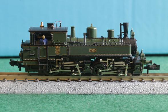 Side view of a green tank engine with two sets of cylinders, each driving a pair of wheels.