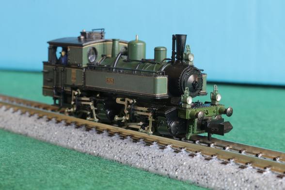 Front quarter view of a green tank engine with two sets of cylinders, each driving a pair of wheels.