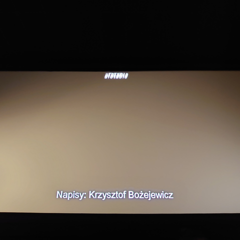 Zdjęcie ekranu kinowego, na którym pokazany jest tekst: „Napisy: Krzysztof Bożejewicz”.